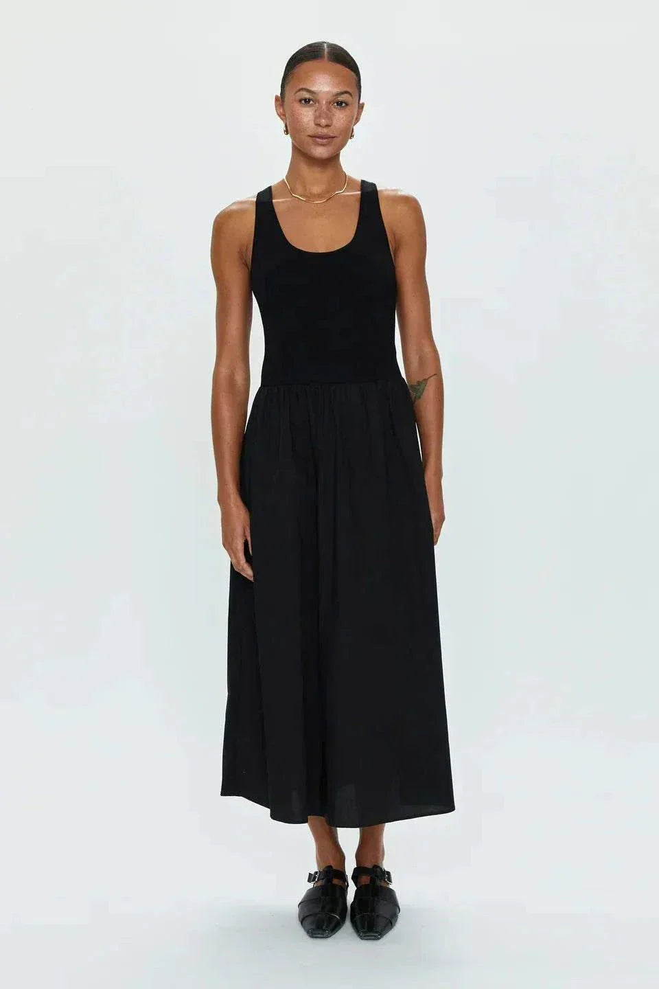 Woman wearing Faye Tank Dress in noir with sleeveless design and relaxed skirt