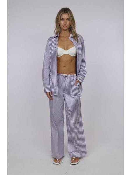 Woman wearing The Avril Violet striped pajama set by SOLID&STRIPED with open shirt and pants