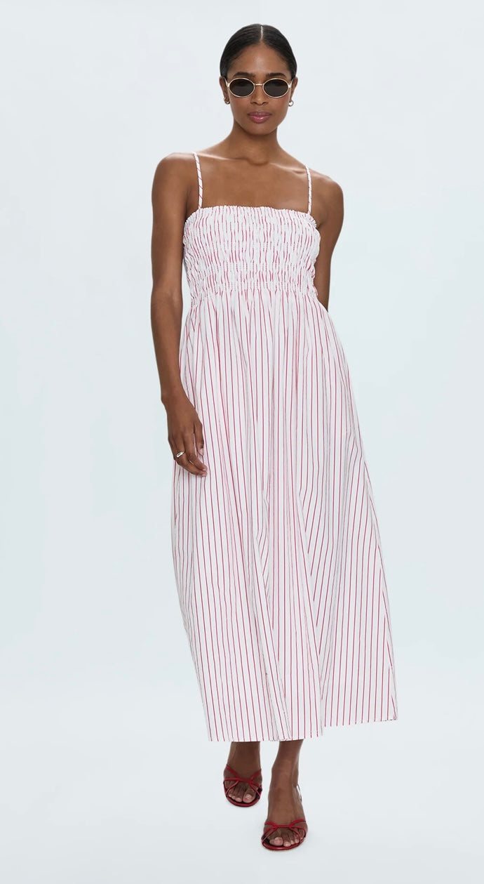 Woman wearing Bianca Shirred Dress with ruby red stripes and ruched bodice, midi length summer style