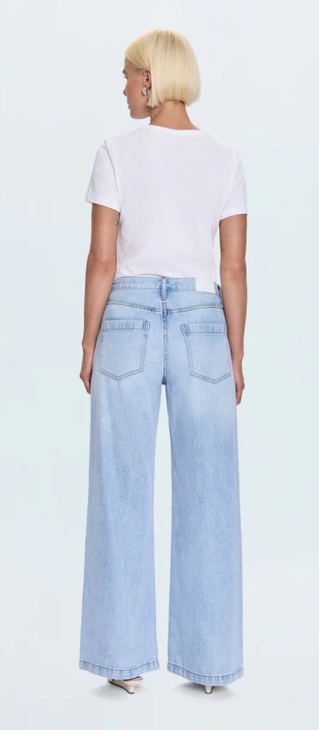 Back view of woman wearing Jadyn Low Slung Palazzo Jeans in light blue wash with vintage fading and whiskering
