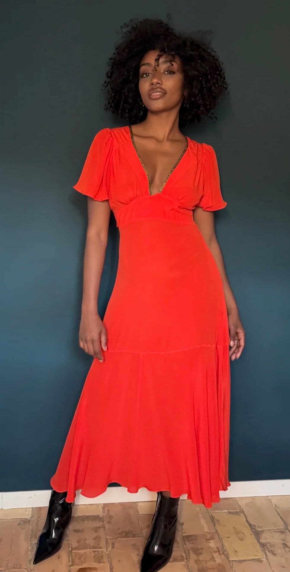 The Iris Fire Red dress by HANSINE LONDON worn by model with black boots