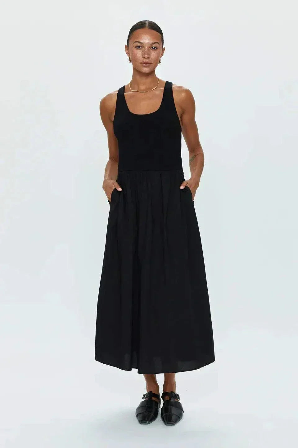 Woman wearing Faye Tank Dress in noir with sleeveless design and relaxed skirt