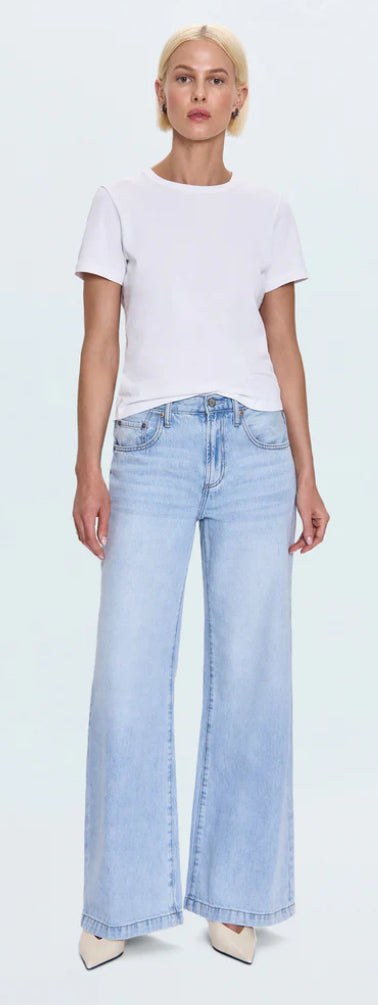 Woman wearing Jadyn Low Slung Palazzo Jeans in light blue wash with white t-shirt and heels