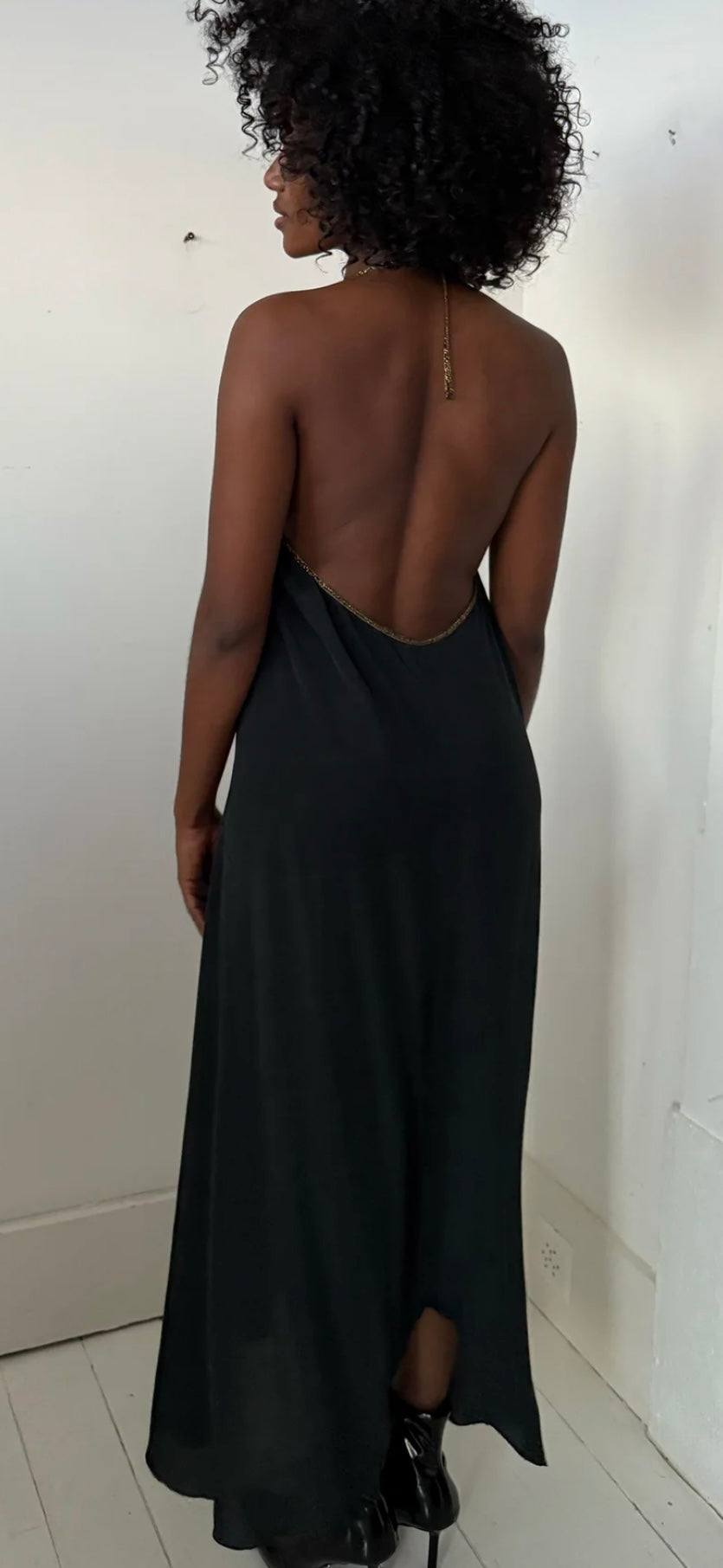 Back view of Rhodes Dress by HANSINE LONDON in pure black with high-low hemline and open back design