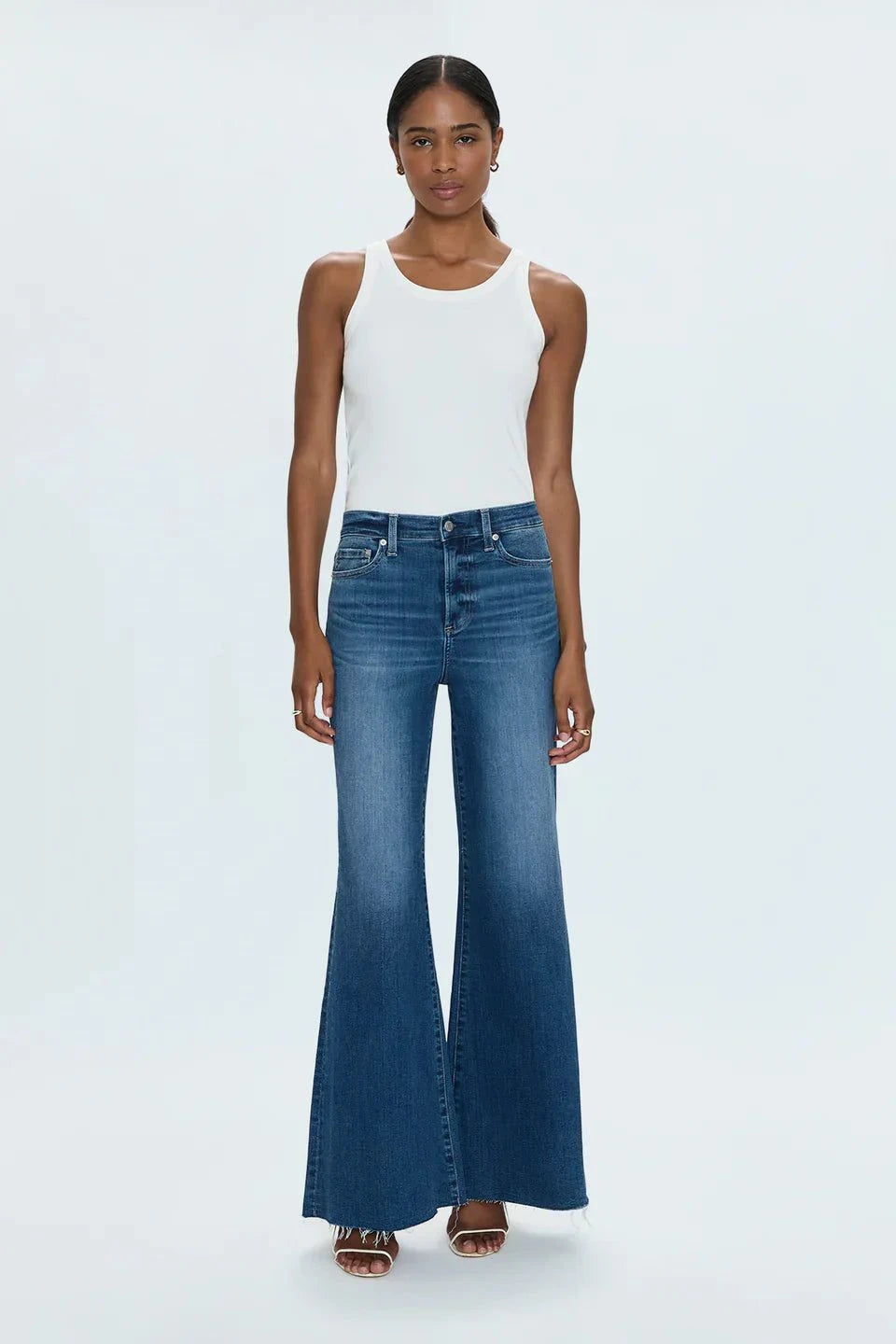 Woman wearing Izzy Jeans Study PISTOLA high-rise slim straight-leg denim jeans with worn-in wash and white tank top