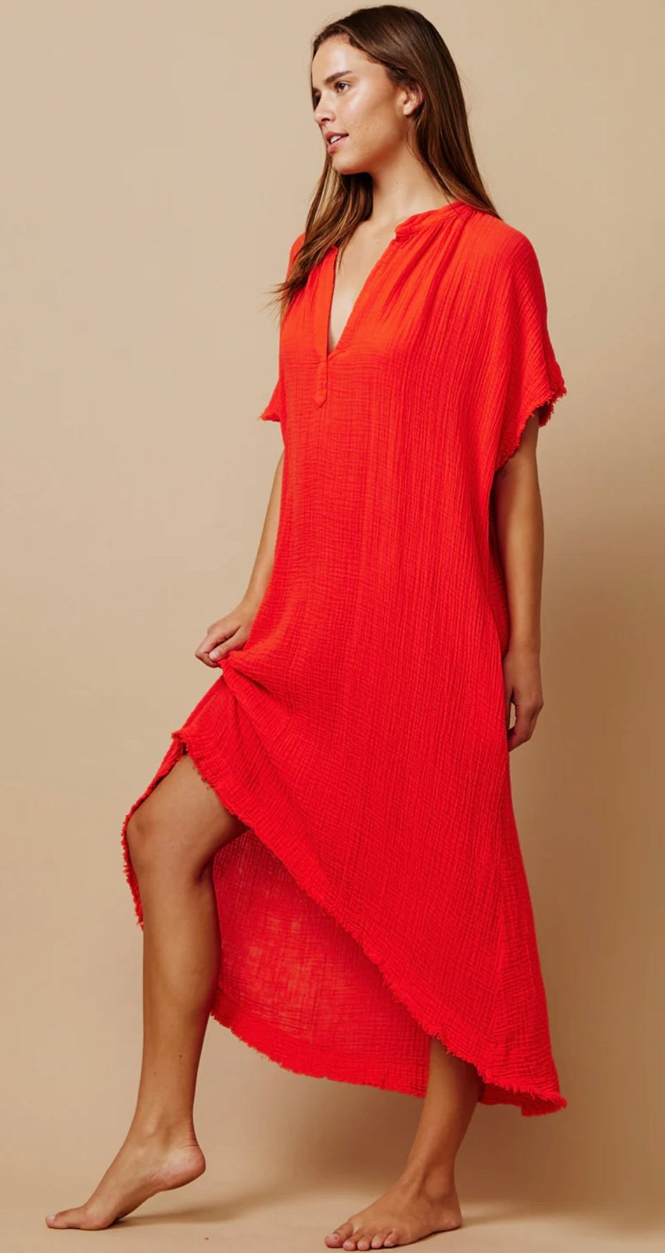 Woman wearing bright red Tunisia caftan dress with short sleeves and side slit