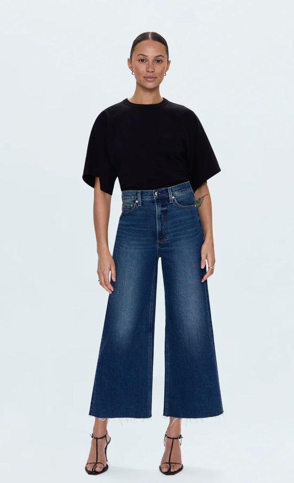 Woman wearing high-rise Lana Cropped wide-leg dark wash denim jeans with raw hem and cropped 27-inch inseam