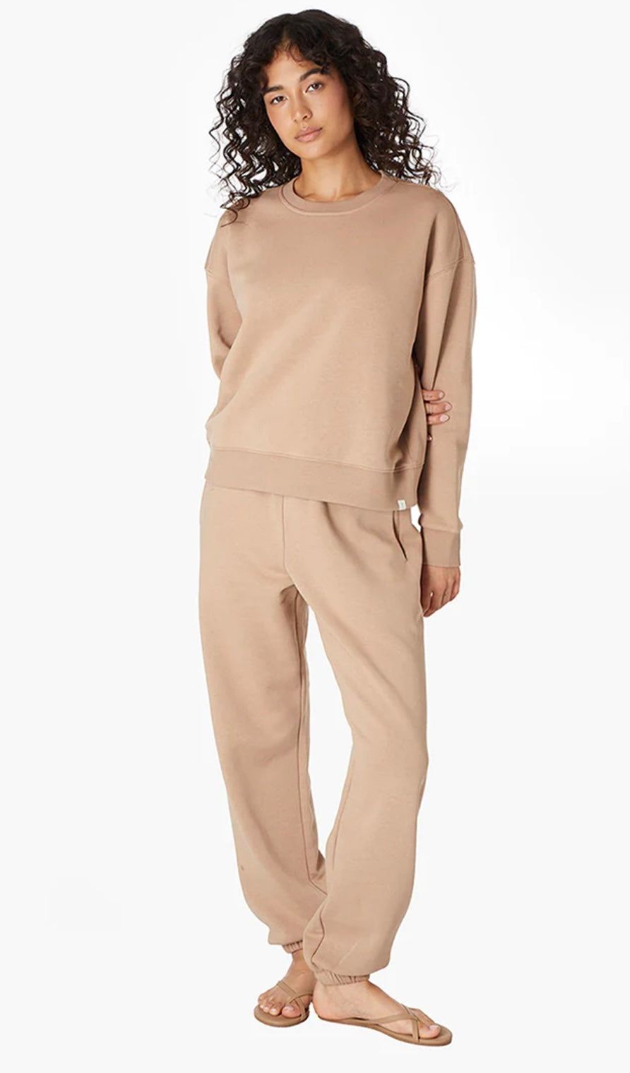 woman wearing camel air whipped crew and pants set by TKEES standing against white background