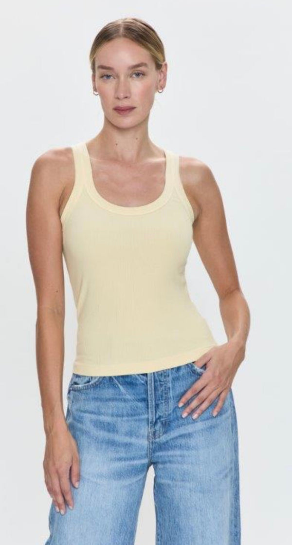Woman wearing Christy Tank Sunshine in light yellow paired with blue denim jeans