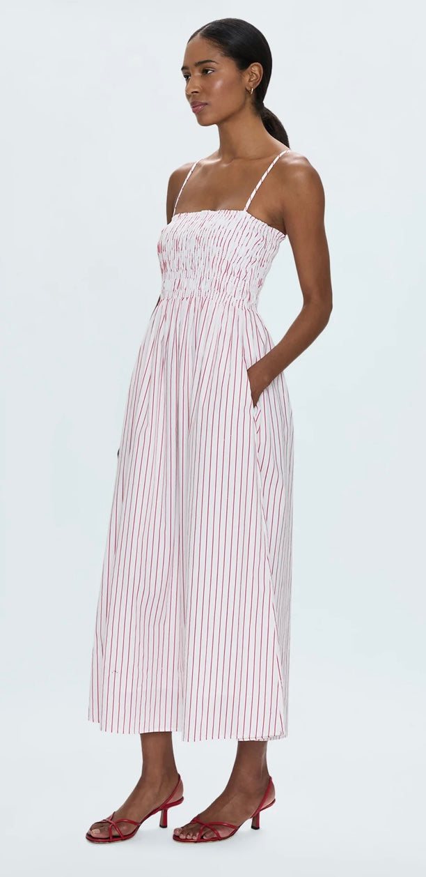 Woman wearing Bianca Shirred Dress with ruby red stripes and ruched bodice, midi length summer style