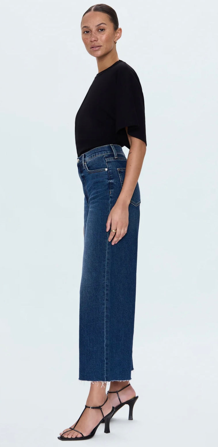 woman wearing Lana Cropped high-rise wide-leg dark wash denim jeans with raw hem and relaxed fit