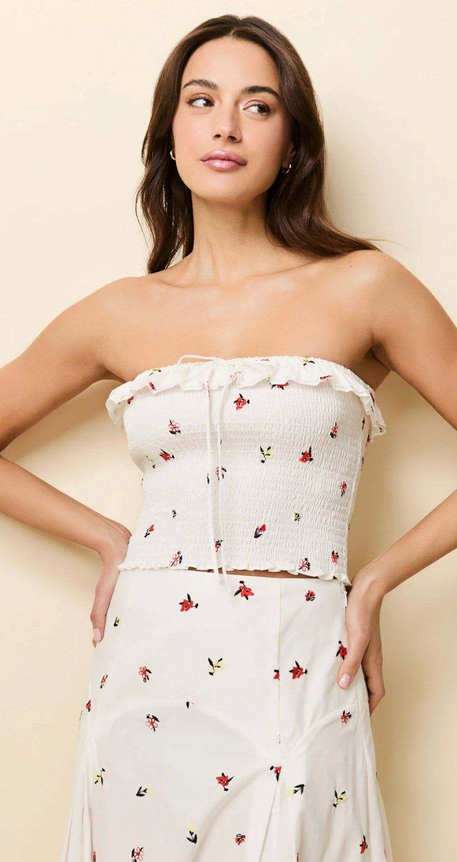 Woman wearing The Nikki Embroided Top optic white cropped tube top with floral embroidery and matching skirt