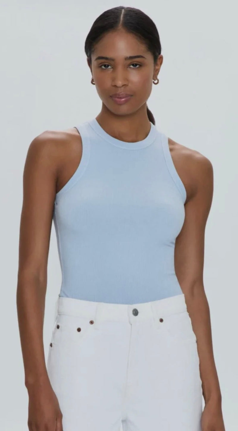 Woman wearing light blue Blake Bodysuit with white pants against white background