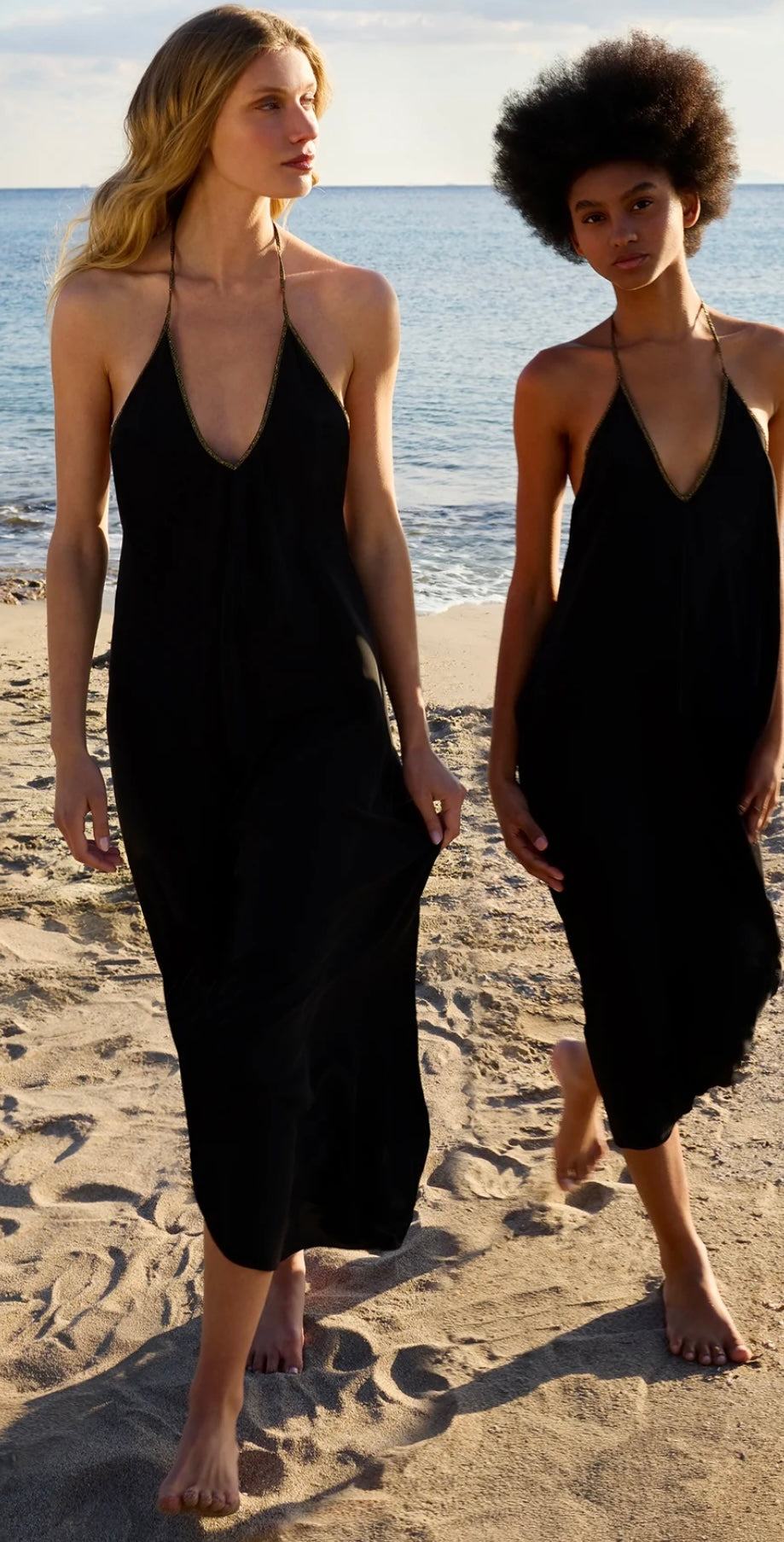 Two women wearing pure black Rhodes Dress by HANSINE LONDON on the beach