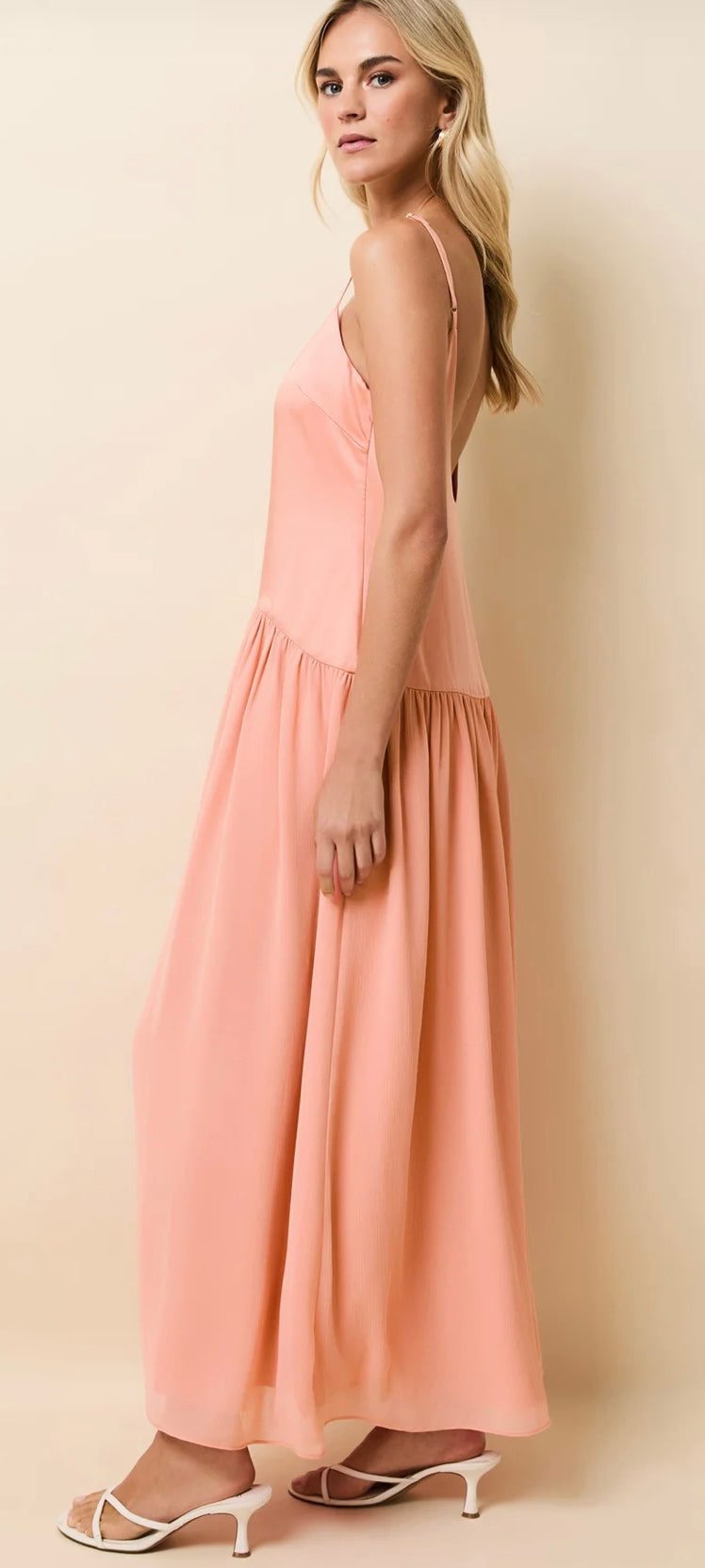 Woman wearing peach Talulla Pechykeen silky bodice dress with overlay skirt and adjustable straps