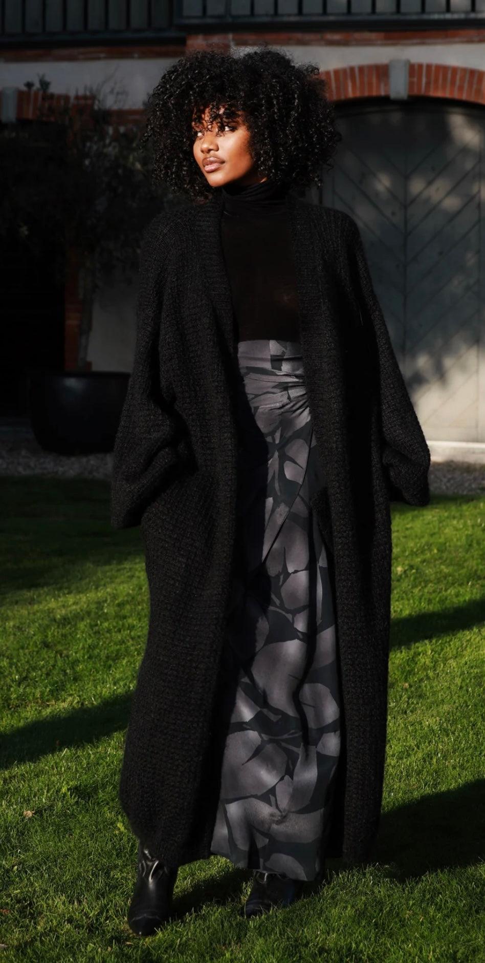 Woman wearing The Long Mohair Coat Noir in black standing outdoors