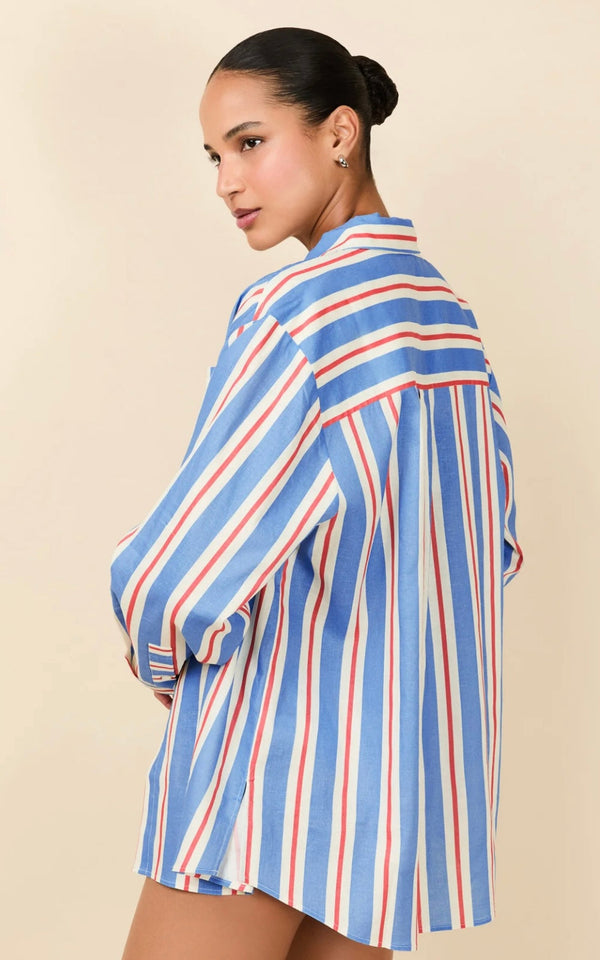 Woman wearing The Avril Button Down striped linen shirt in blue, white, and red Americana stripes viewed from the back