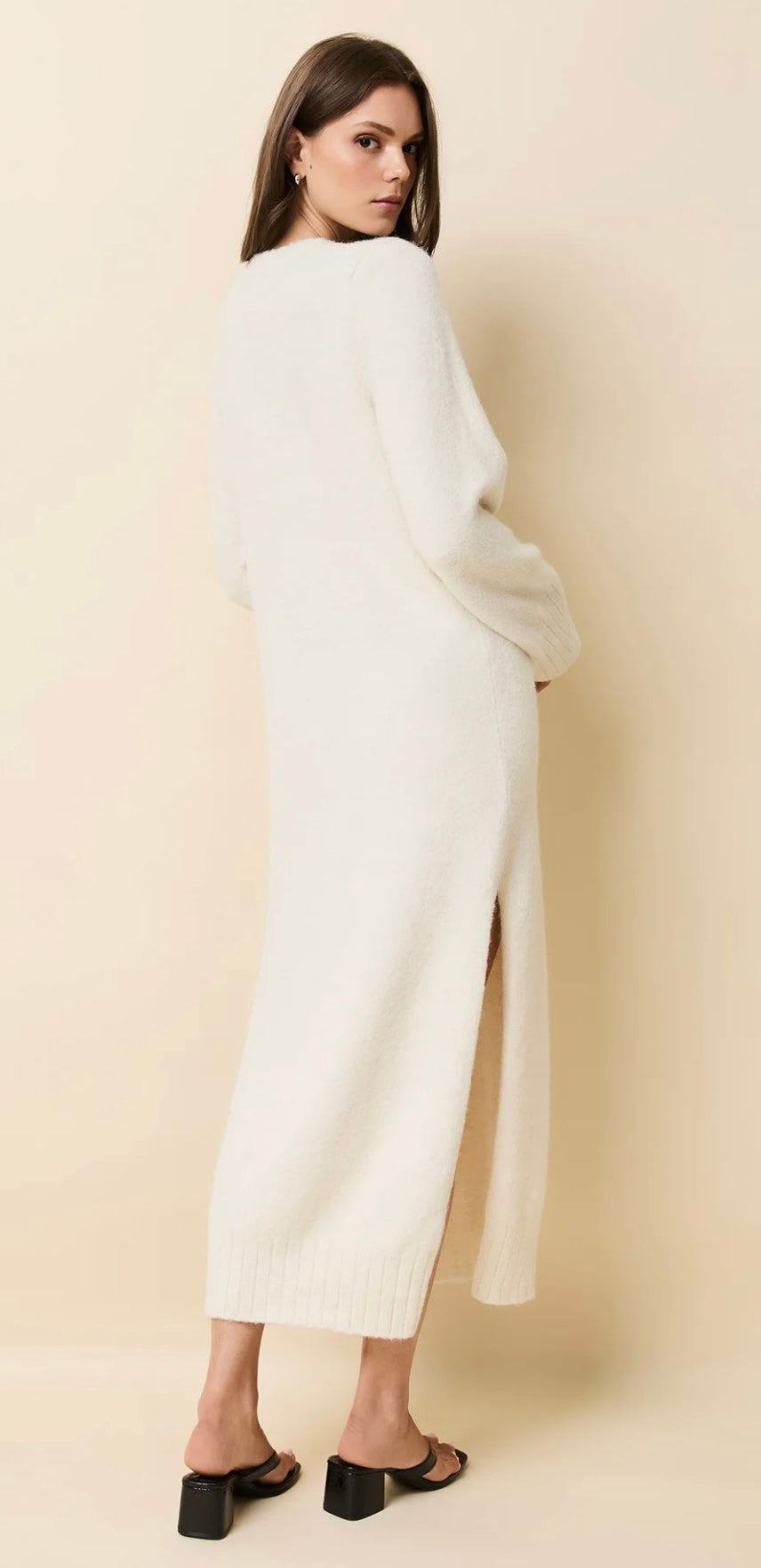 The Edith Dress Brulé by SOLID&STRIPED in cream with v-neck, flared sleeves, side slits, and ribbed details, styled with black heels.