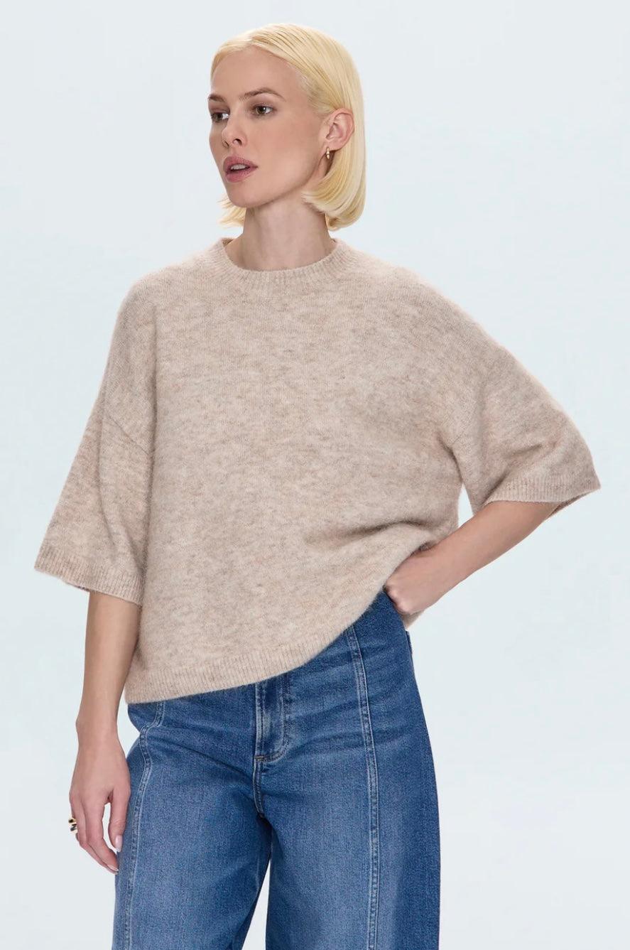 Woman wearing oatmeal Shiloh Sweater with short sleeves and crewneck, paired with blue jeans