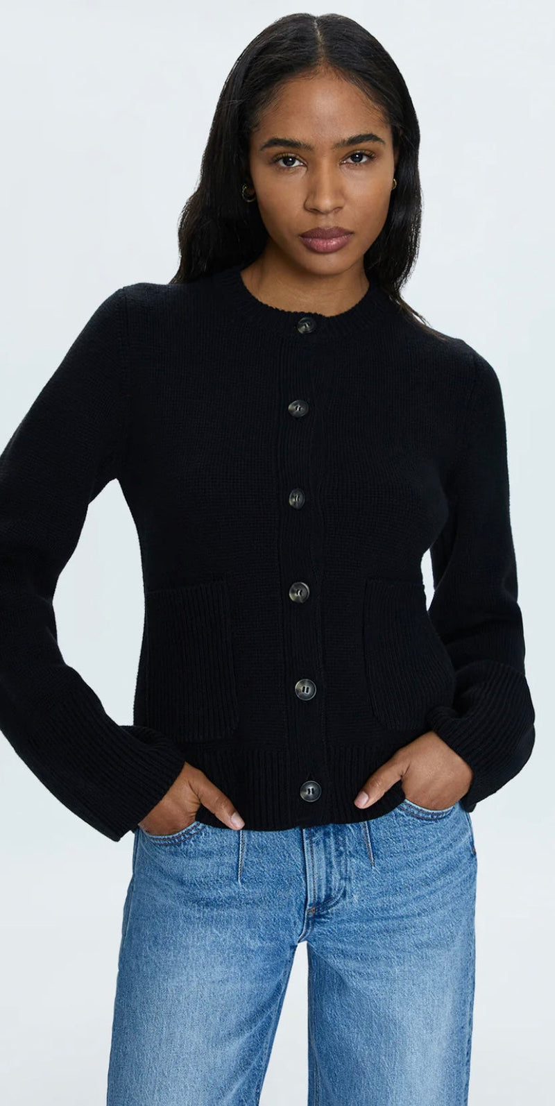Woman wearing black Dani Noir PISTOLA DENIM button-front cardigan with cinched waist and blue denim jeans