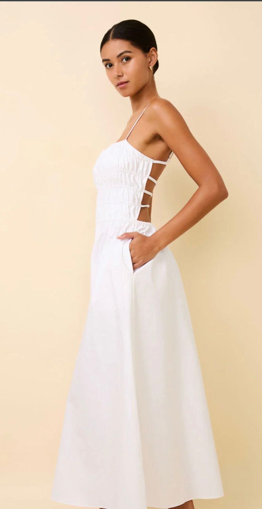 Woman wearing The Delta White SOLID&STRIPED midi dress with smocked bodice and exposed elastic back straps