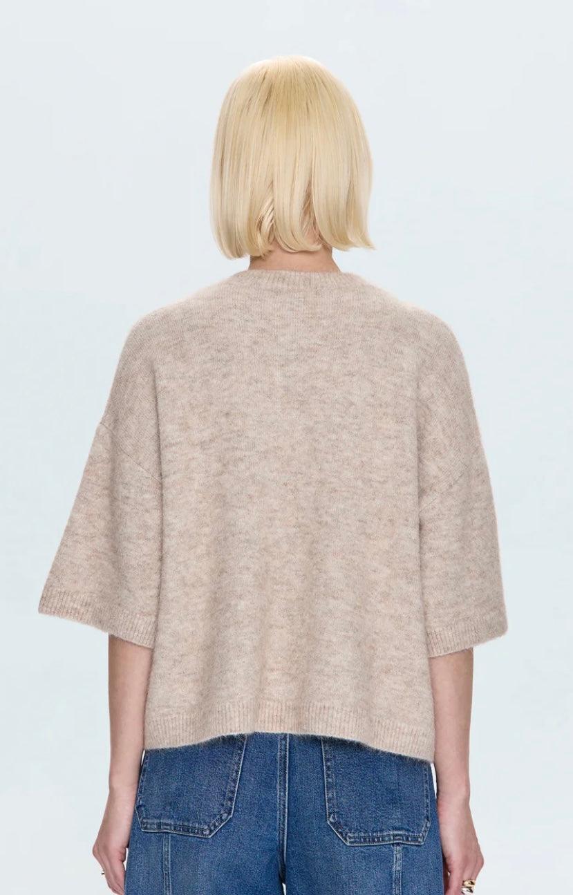 Back view of model wearing Shiloh Sweater in oatmeal with short sleeves and relaxed fit