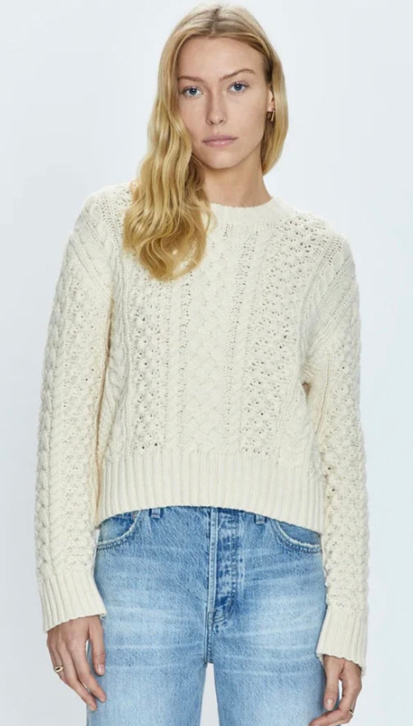 Woman wearing Quinn Ivory cable knit sweater with blue denim jeans