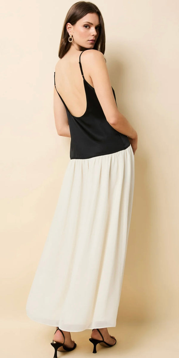 Woman wearing The Tallula Noir black sleeveless top with low back and white wide-leg pants