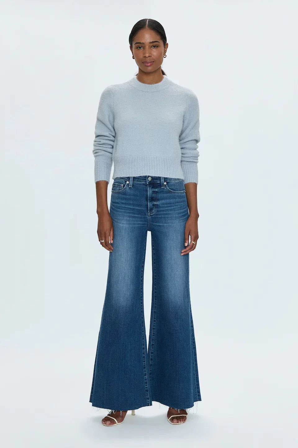Woman wearing high-rise Izzy Jeans Study PISTOLA with a slim waist and flared legs in a subtle worn-in wash.