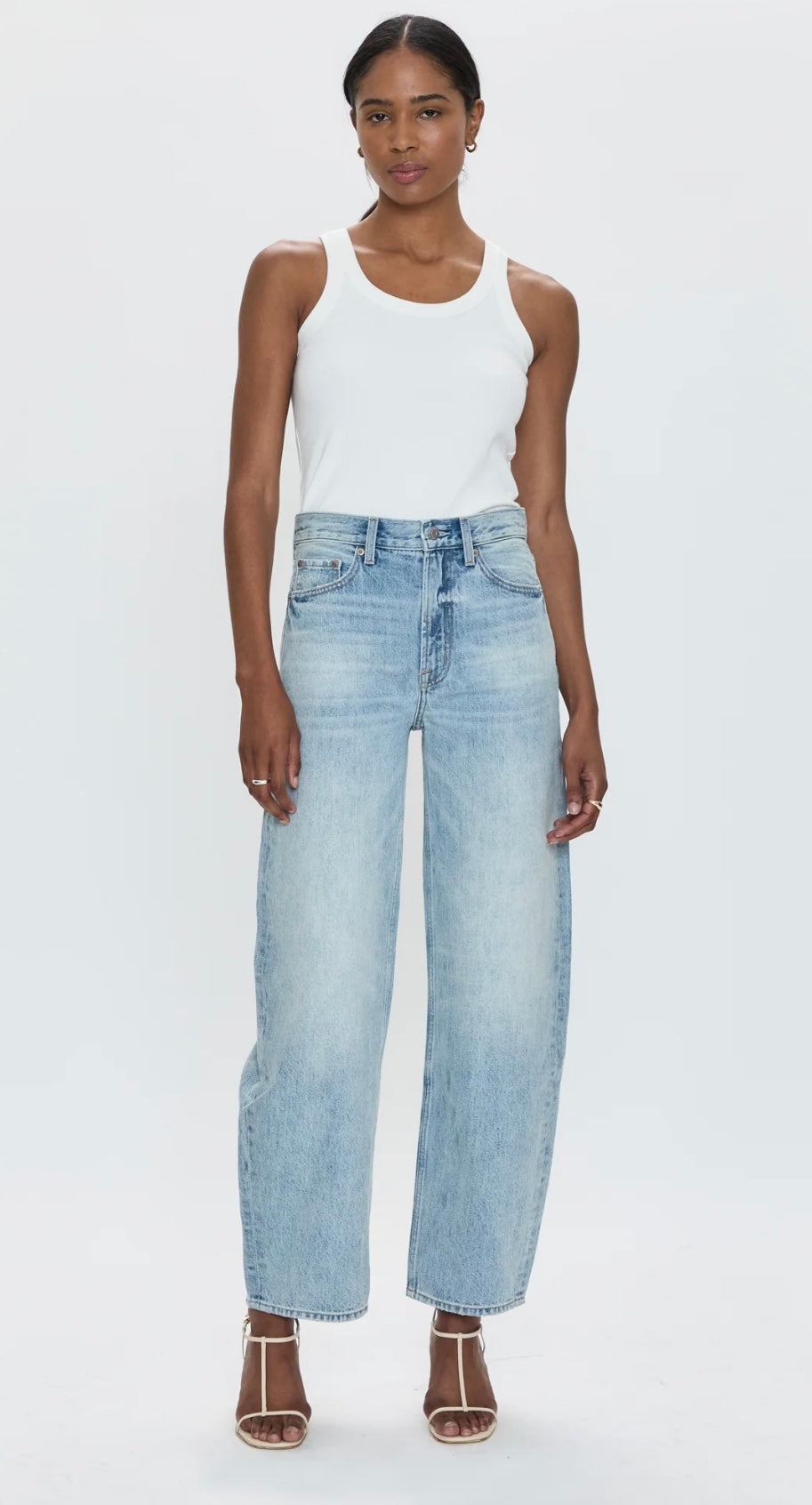 Woman wearing Wes High Rise Barrel Pistola Denim jeans with white tank top and heels