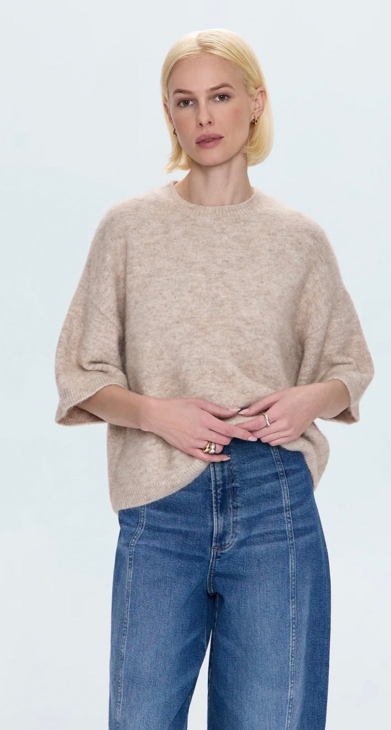 Woman wearing oatmeal Shiloh Sweater with crewneck and short sleeves paired with blue denim jeans