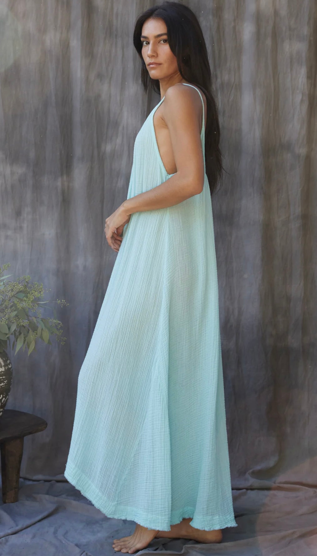 Woman wearing a light blue Tulum Dress Ocean with a flowing, sleeveless design against a neutral backdrop
