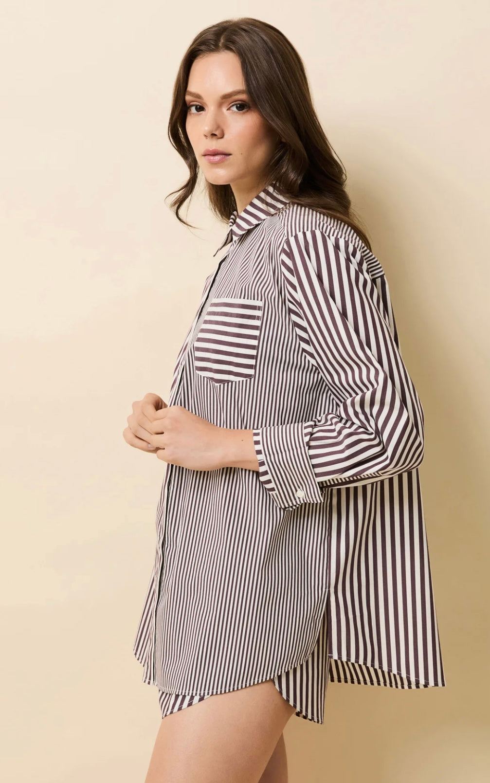 Woman wearing The Avril Shirt by SOLID&STRIPED in raisin brown striped pattern with relaxed fit and mother of pearl buttons