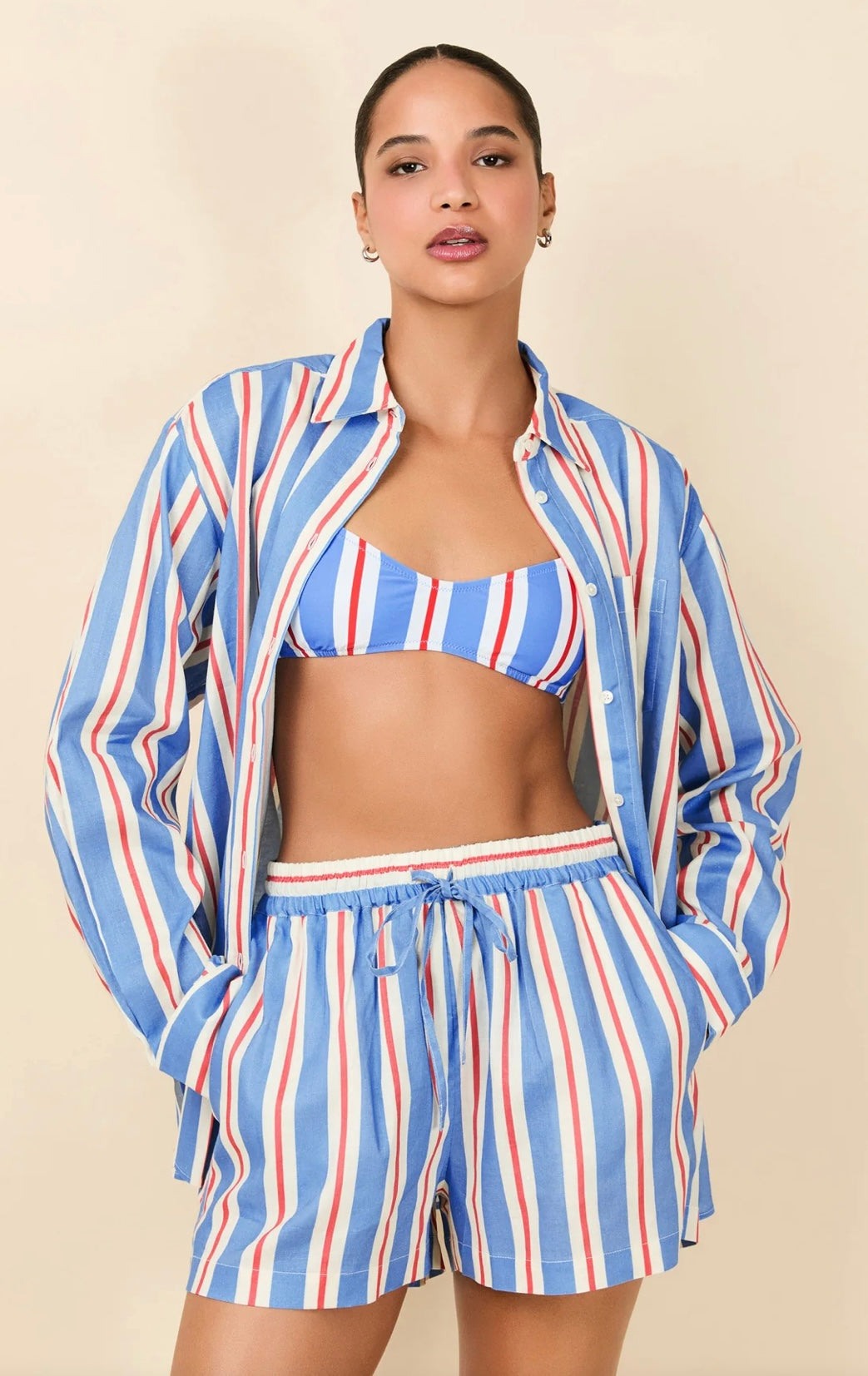 Model wearing The Avril Button Down Americana striped linen shirt with matching shorts and bikini top