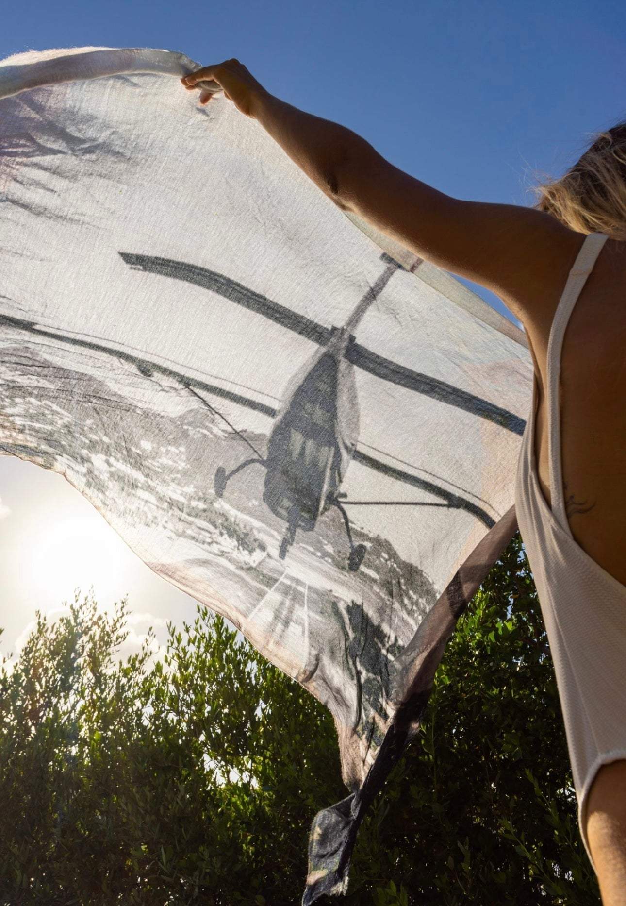 Lightweight cashmere "St Barth Landing" pareo with helicopter print worn as scarf or beach cover-up