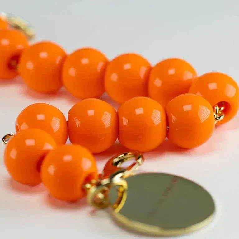 Mini Beads Bracelet in bright neon orange with adjustable length and gold charm detail by Vanessa Baroni