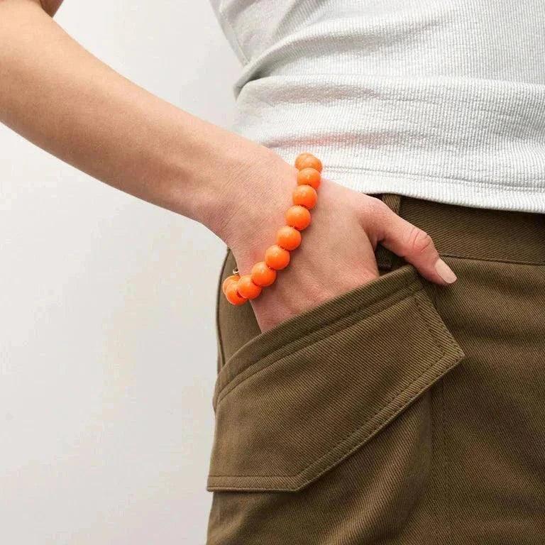 Mini Beads Bracelet in neon orange worn on wrist with casual outfit