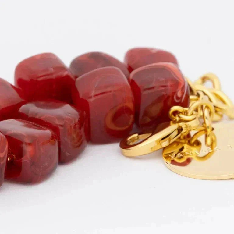 Organic shaped beads bracelet in red marble with gold clasp and charm accents