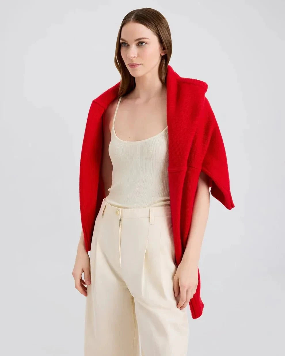 Woman wearing Selena Tank ecru with red sweater draped over shoulders and cream pants