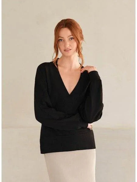 Woman wearing black V-Neck Lux Terry Top with deep neckline and long sleeves.